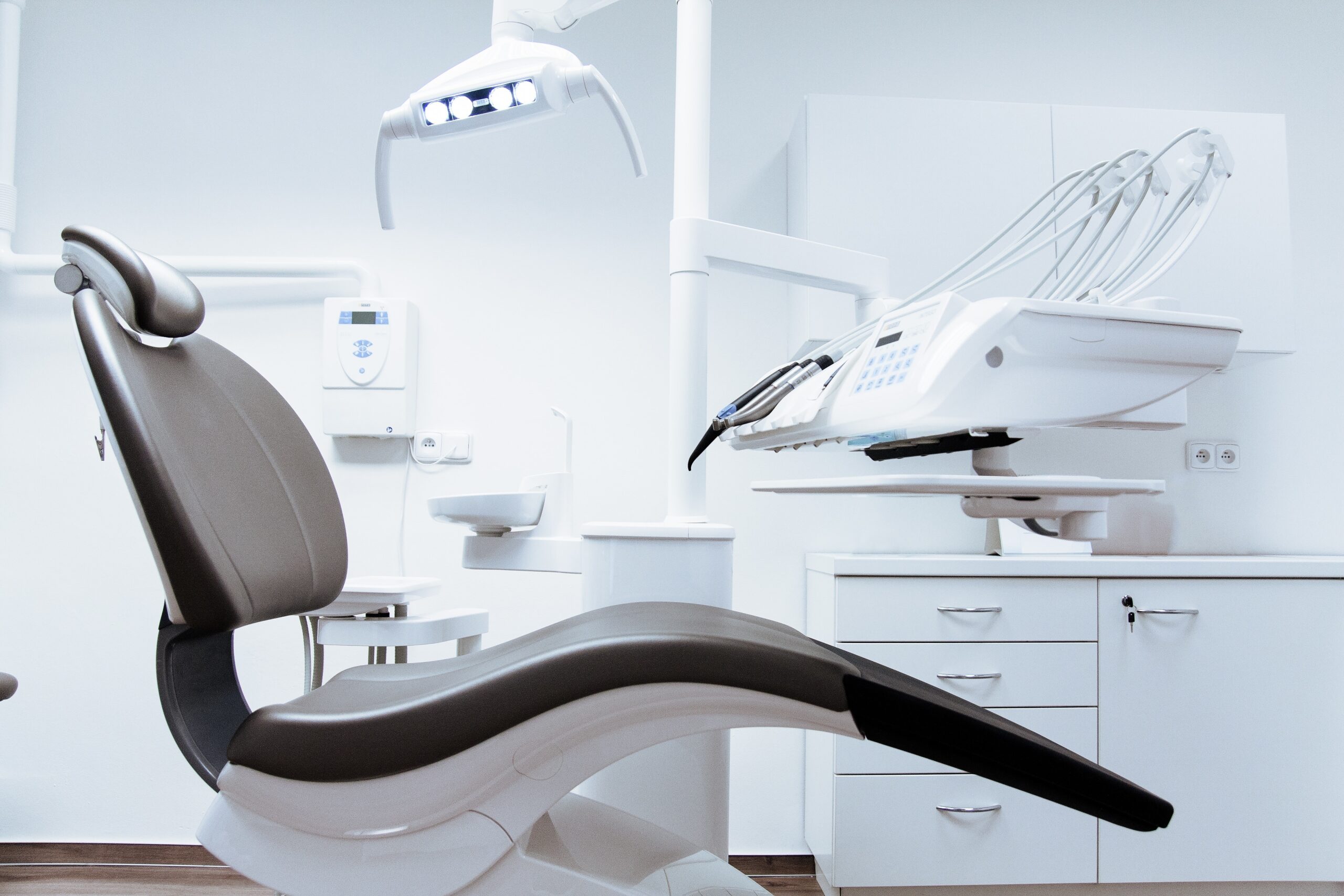 Empty dentist chair in a modern and clean dental office . Empty dentist chair in a modern and clean dental office .